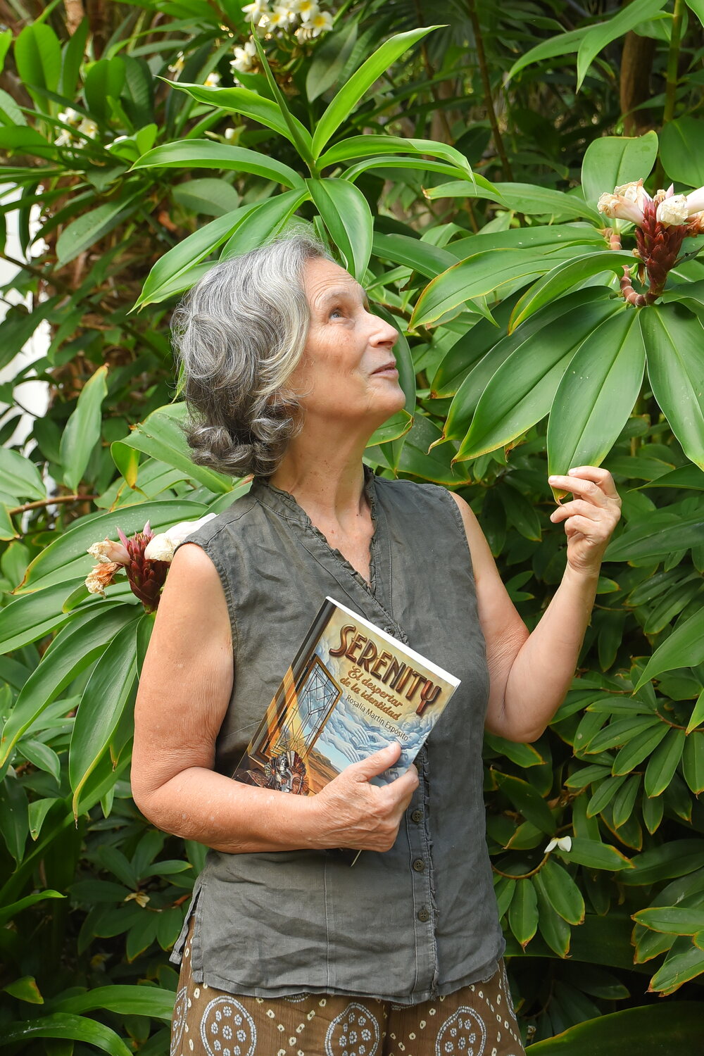 Rosalía Martín Expósito entre la vegetación con su libro