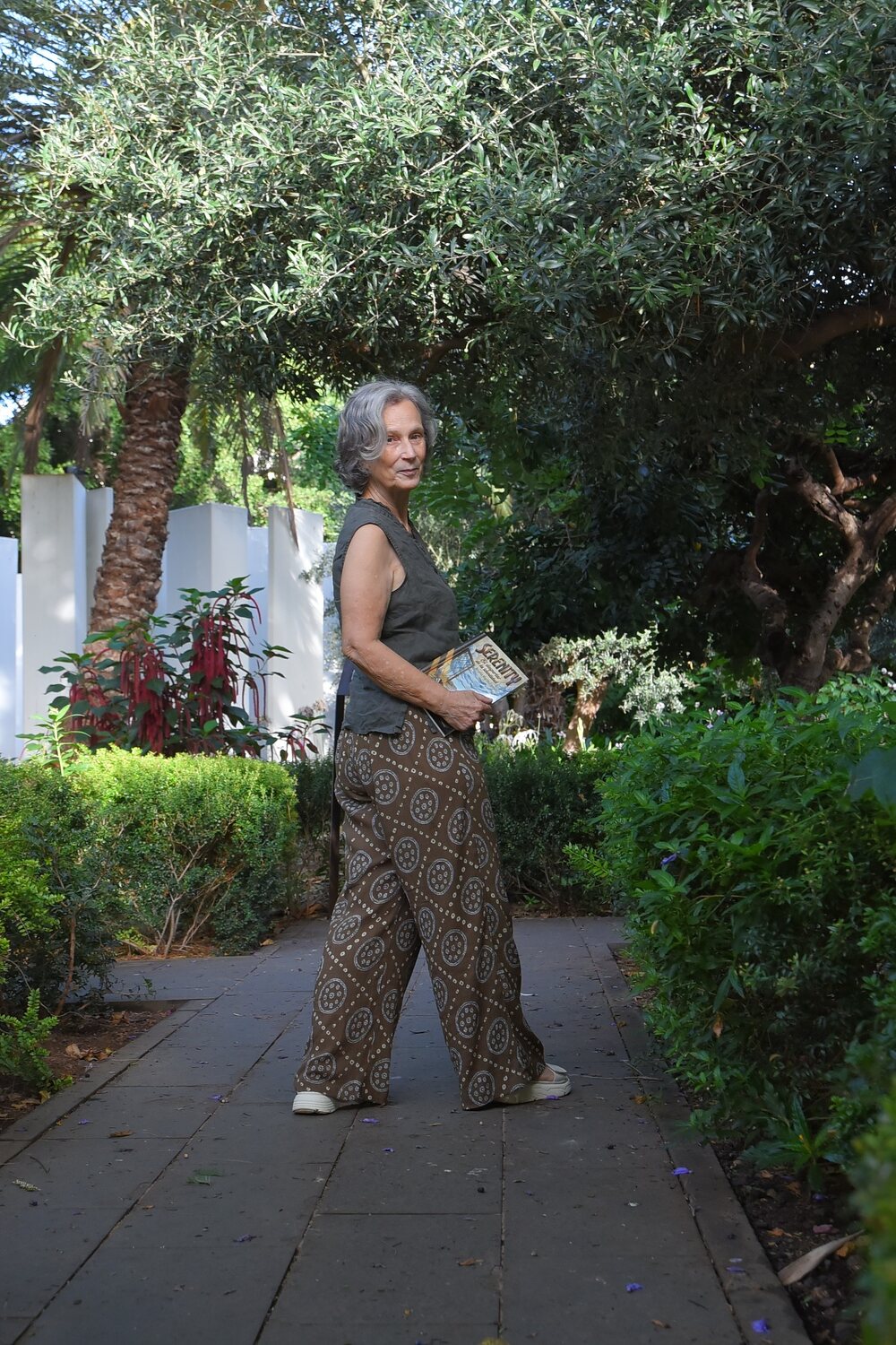 Rosalía Martín Expósito caminando por un jardín con su libro